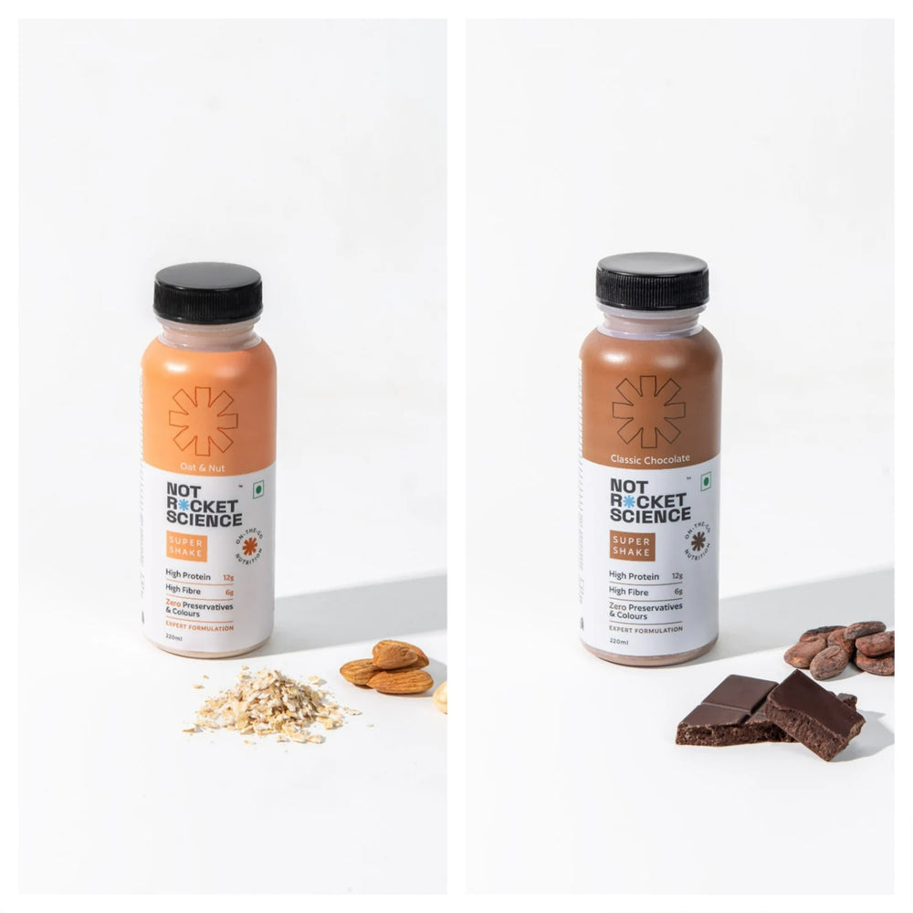 Two ‘NOT ROCKET SCIENCE’ shake bottles, one with oats and the other with chocolate and almonds, against a neutral background